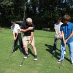 A gentleman gives a golf lesson at Pine Meadows Golf Club